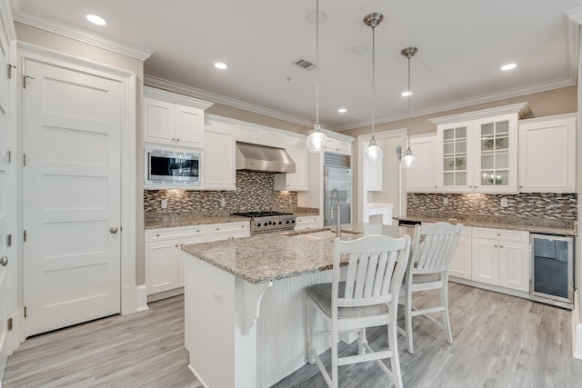 4134 Cobalt Cir Unit Ro14, Panama City, FL 32408 - kitchen with under cabinet range hood, built in appliances, wine cooler, a sink, and light wood finished floors