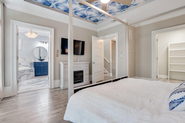 4134 Cobalt Cir Unit Ro14, Panama City, FL 32408 - bedroom featuring crown molding, light wood finished floors, ensuite bathroom, a glass covered fireplace, and baseboards