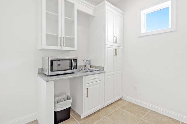 52 Tranquility Ln, Destin, FL 32541 - kitchen with stainless steel microwave, baseboards, glass insert cabinets, light countertops, and white cabinets