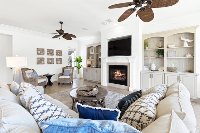 52 Tranquility Ln, Destin, FL 32541 - living area with ceiling fan, crown molding, light tile patterned flooring, built in features, and a glass covered fireplace