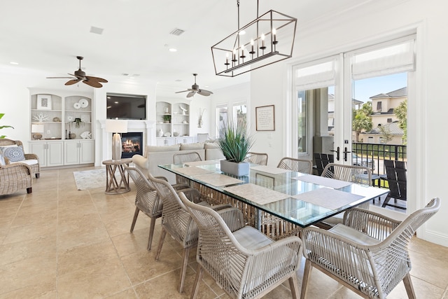 52 Tranquility Ln, Destin, FL 32541 - dining area featuring ceiling fan, light tile patterned floors, a glass covered fireplace, crown molding, and recessed lighting