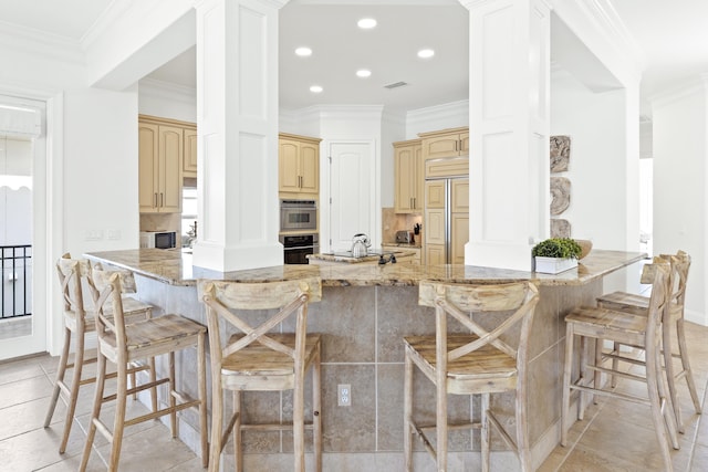 52 Tranquility Ln, Destin, FL 32541 - kitchen featuring paneled refrigerator, decorative columns, a peninsula, a breakfast bar area, and recessed lighting