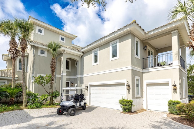 52 Tranquility Ln, Destin, FL 32541 - view of front facade with an attached garage, a balcony, stucco siding, and driveway