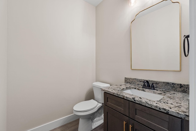 1511 23rd St, Niceville, FL 32578 - half bathroom with wood finished floors, vanity, toilet, and baseboards
