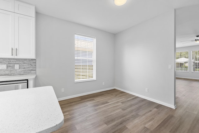 518 Second Ave, Destin, FL 32541 - unfurnished dining area with wood finished floors, ceiling fan, a glass covered fireplace, and baseboards