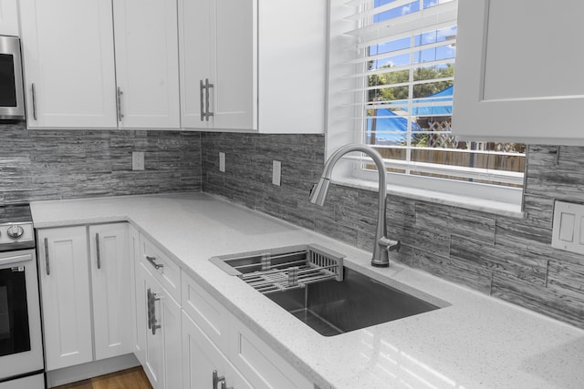 518 Second Ave, Destin, FL 32541 - kitchen featuring a sink, white cabinetry, decorative backsplash, and light stone countertops