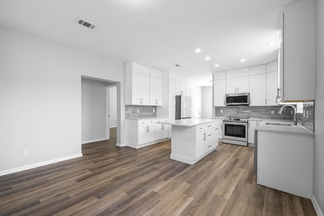 518 Second Ave, Destin, FL 32541 - kitchen featuring appliances with stainless steel finishes, a sink, decorative backsplash, dark wood finished floors, and baseboards
