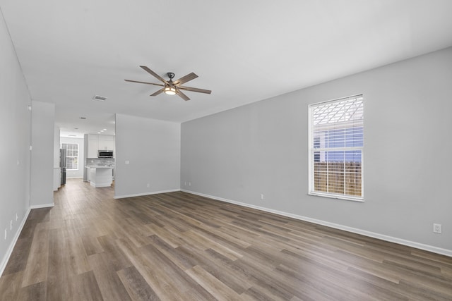518 Second Ave, Destin, FL 32541 - unfurnished living room with a ceiling fan, plenty of natural light, dark wood finished floors, and baseboards