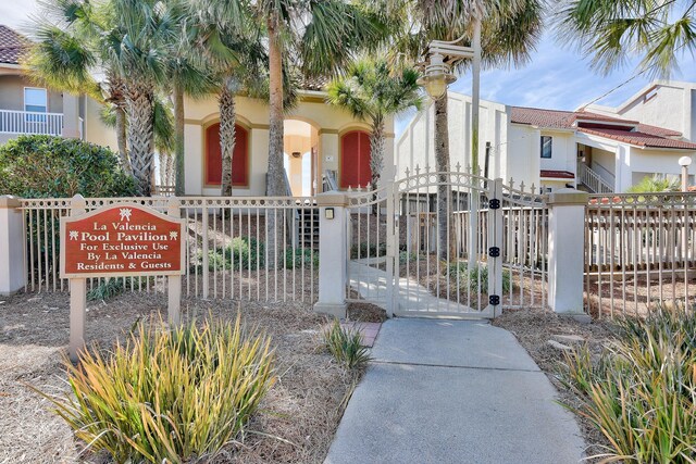 431 La Valencia Cir, Panama City Beach, FL 32413 - view of front of home featuring a fenced front yard, stucco siding, a gate, and a tiled roof