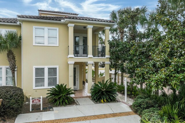 431 La Valencia Cir, Panama City Beach, FL 32413 - view of front of property featuring stucco siding, a balcony, covered porch, french doors, and a tiled roof