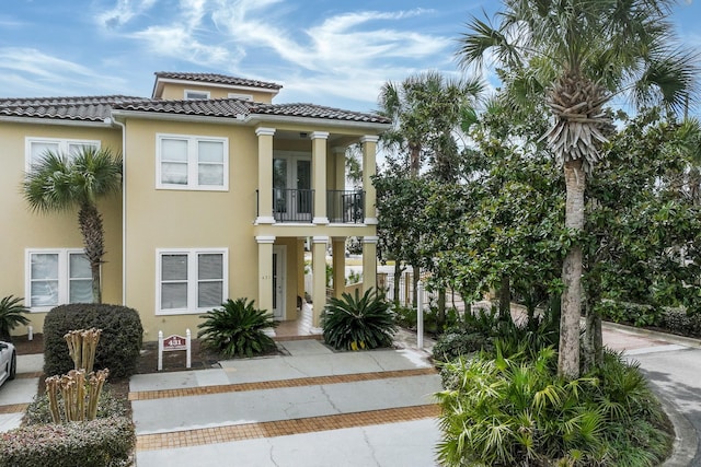 431 La Valencia Cir, Panama City Beach, FL 32413 - view of front of property featuring a balcony, stucco siding, a tile roof, and french doors