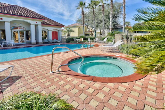 431 La Valencia Cir, Panama City Beach, FL 32413 - community pool with french doors, a hot tub, and a patio area