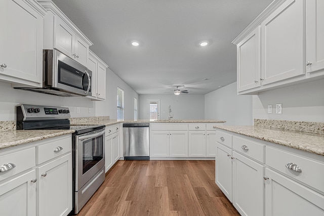 103 Ridgeway Cir, Crestview, FL 32536 - kitchen featuring stainless steel appliances, a ceiling fan, light wood finished floors, white cabinetry, and recessed lighting