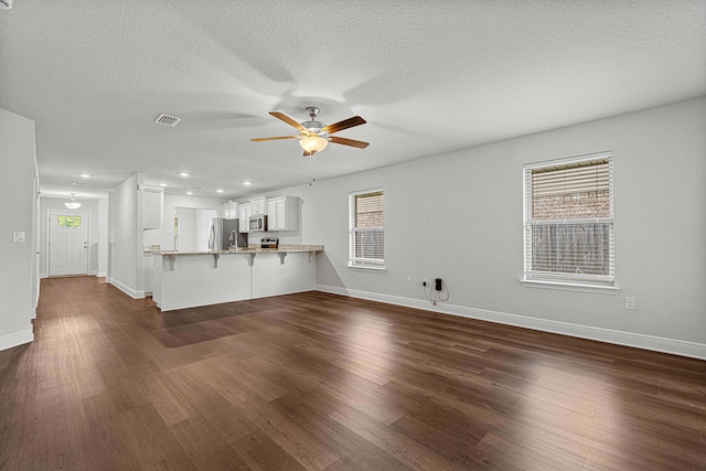 103 Ridgeway Cir, Crestview, FL 32536 - unfurnished living room with ceiling fan, dark wood-style flooring, baseboards, a textured ceiling, and recessed lighting