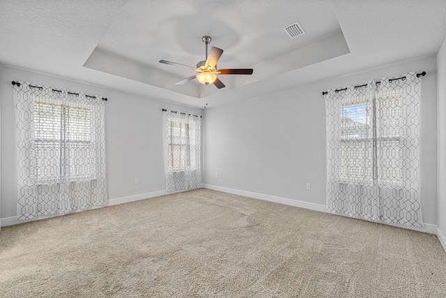 103 Ridgeway Cir, Crestview, FL 32536 - empty room with a tray ceiling, ceiling fan, baseboards, a textured ceiling, and carpet flooring