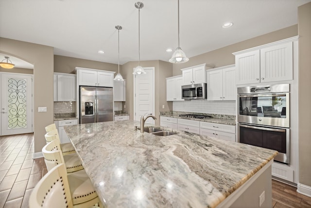 20 6th Ave, Shalimar, FL 32579 - kitchen with stainless steel appliances, a sink, dark wood-style floors, decorative backsplash, and a large island