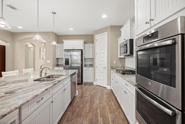 20 6th Ave, Shalimar, FL 32579 - kitchen featuring stainless steel appliances, arched walkways, a sink, white cabinets, and recessed lighting