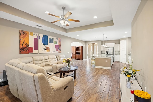 20 6th Ave, Shalimar, FL 32579 - living area featuring arched walkways, a ceiling fan, wood finished floors, recessed lighting, and a tray ceiling