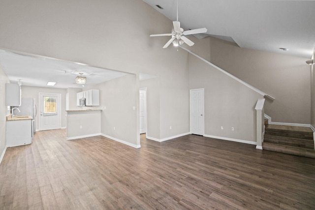 1014 Airport Rd Unit 155, Destin, FL 32541 - unfurnished living room with stairway, dark wood-style floors, ceiling fan, baseboards, and high vaulted ceiling