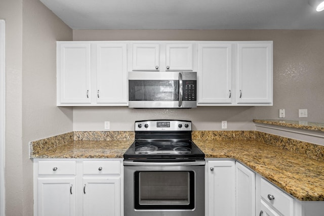 1014 Airport Rd Unit 155, Destin, FL 32541 - kitchen featuring stainless steel appliances, white cabinets, and light stone counters