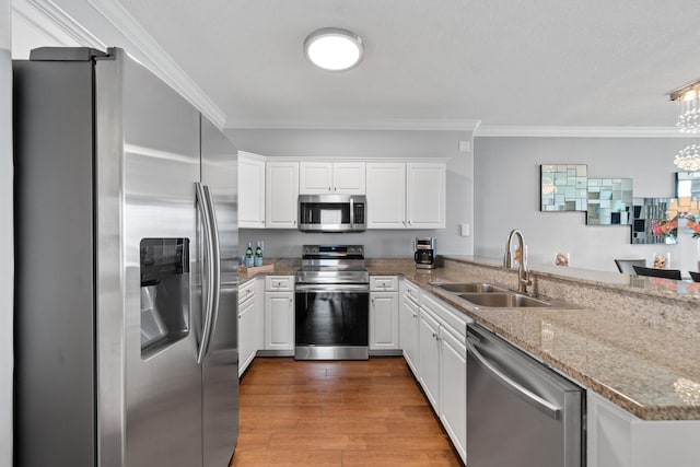 17545 Front Beach Rd Unit 1301, Panama City Beach, FL 32413 - kitchen with stainless steel appliances, a sink, crown molding, white cabinetry, and a peninsula