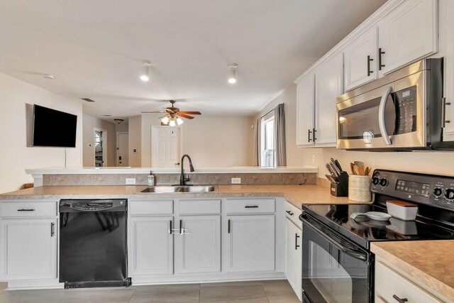 1951 Ambassador Dr, Gulf Breeze, FL 32563 - kitchen featuring black appliances, a sink, a peninsula, white cabinetry, and a ceiling fan