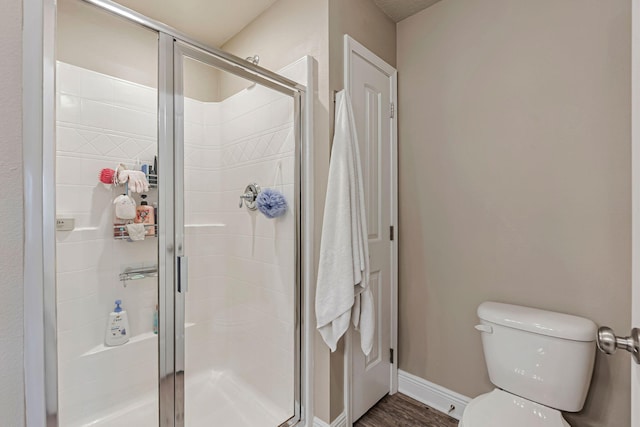 8726 Brown Pelican Cir, Navarre, FL 32566 - bathroom featuring toilet, a stall shower, baseboards, and wood finished floors