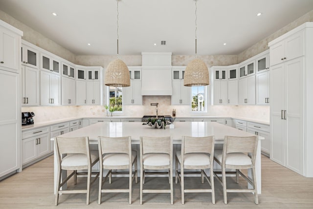 4658 Destiny Way, Destin, FL 32541 - kitchen with a kitchen island, light wood-style flooring, white cabinets, a breakfast bar, and recessed lighting