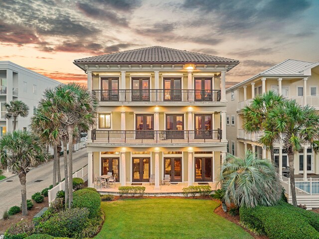17 Saint Martin Cir, Miramar Beach, FL 32550 - back of house featuring french doors, a balcony, a lawn, and stucco siding