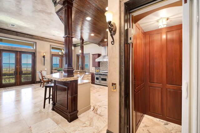 17 Saint Martin Cir, Miramar Beach, FL 32550 - kitchen featuring range with two ovens, light stone countertops, french doors, wall chimney exhaust hood, and decorative backsplash