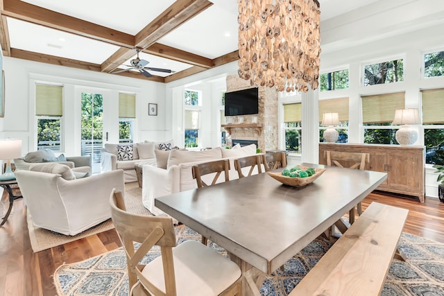 18 Eastern Lake Ct, Santa Rosa Beach, FL 32459 - dining room with a stone fireplace, wood finished floors, beam ceiling, ceiling fan, and coffered ceiling