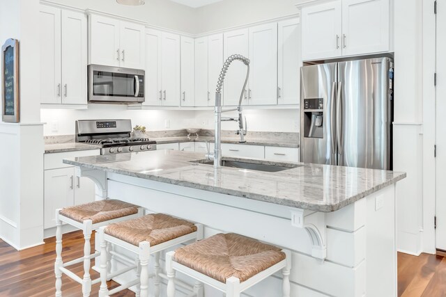 18 Eastern Lake Ct, Santa Rosa Beach, FL 32459 - kitchen featuring appliances with stainless steel finishes, a sink, wood finished floors, and white cabinetry