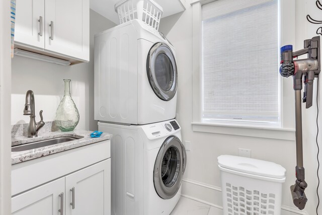 18 Eastern Lake Ct, Santa Rosa Beach, FL 32459 - laundry area featuring estacked washer and dryer, marble look tile flooring, cabinet space, and baseboards