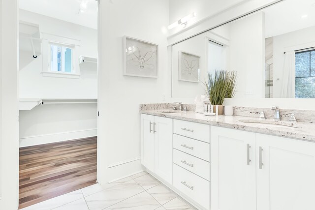 18 Eastern Lake Ct, Santa Rosa Beach, FL 32459 - bathroom featuring double vanity, marble look tiles, baseboards, and a shower