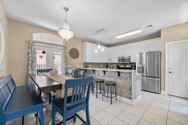 34 Opal Cv, Miramar Beach, FL 32550 - dining space with a chandelier, light tile patterned floors, and french doors