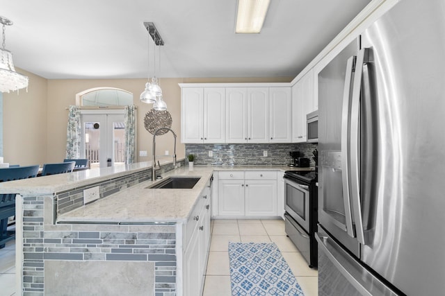 34 Opal Cv, Miramar Beach, FL 32550 - kitchen featuring stainless steel appliances, a sink, light tile patterned floors, a peninsula, and decorative backsplash