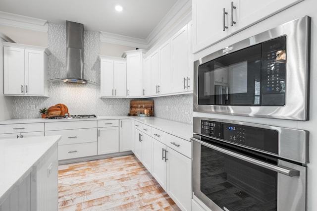 164 Clipper St, Inlet Beach, FL 32461 - kitchen featuring wall chimney range hood, appliances with stainless steel finishes, ornamental molding, light countertops, and white cabinets