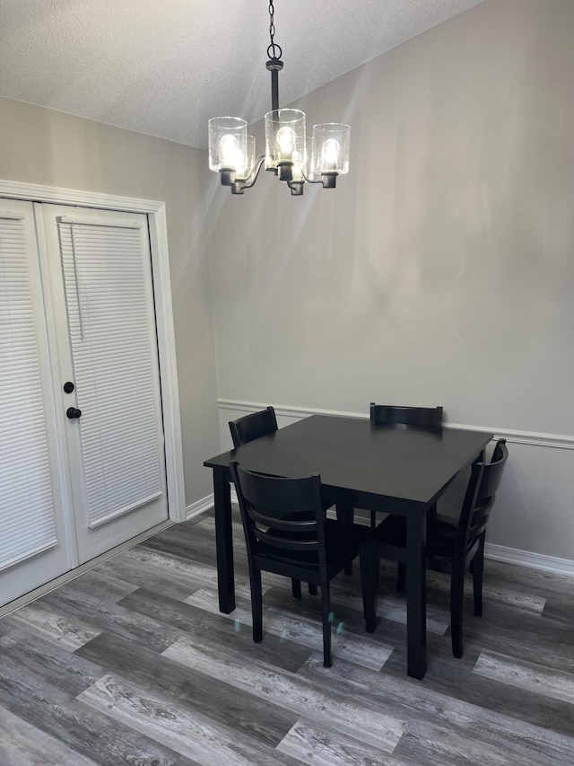 8945 Bluebell St, Milton, FL 32583 - dining room featuring a chandelier, a textured ceiling, dark wood finished floors, and baseboards
