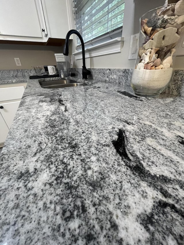 8945 Bluebell St, Milton, FL 32583 - kitchen view of a sink, white cabinets, and stone countertops