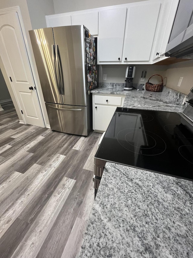 8945 Bluebell St, Milton, FL 32583 - kitchen with appliances with stainless steel finishes, white cabinets, wood finished floors, and light stone countertops