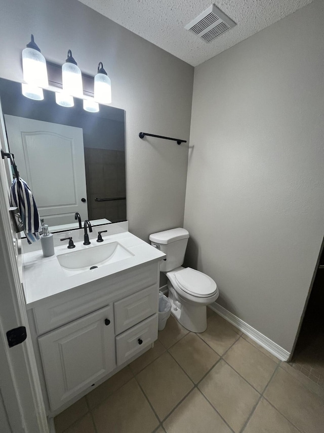 8945 Bluebell St, Milton, FL 32583 - bathroom featuring a textured ceiling, tile patterned flooring, vanity, toilet, and baseboards