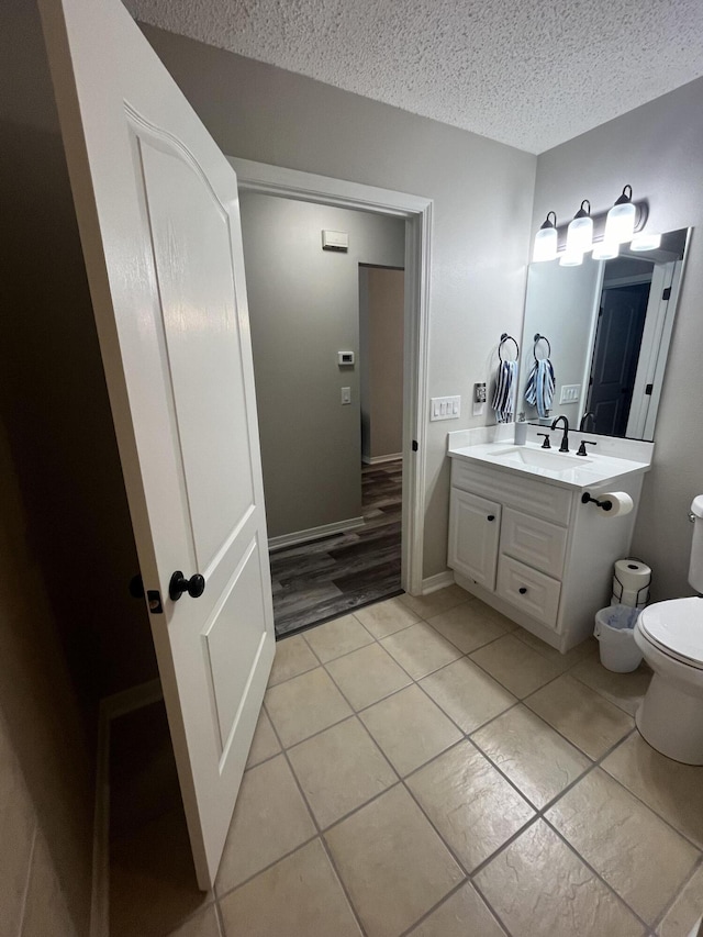 8945 Bluebell St, Milton, FL 32583 - bathroom with toilet, vanity, tile patterned flooring, and a textured ceiling