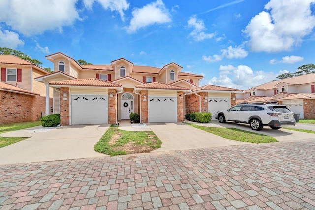 526 Valparaiso Pkwy Unit B, Valparaiso, FL 32580 - view of front of house featuring driveway, brick siding, a tiled roof, and an attached garage