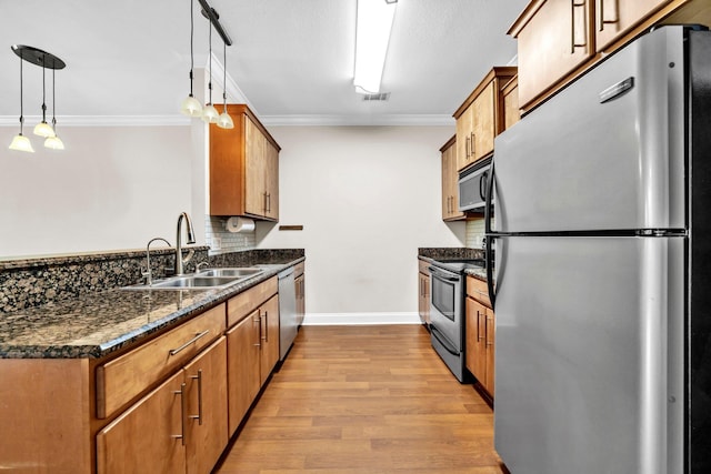 526 Valparaiso Pkwy Unit B, Valparaiso, FL 32580 - kitchen featuring stainless steel appliances, a sink, crown molding, light wood-type flooring, and dark stone countertops