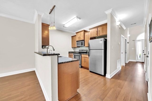 526 Valparaiso Pkwy Unit B, Valparaiso, FL 32580 - kitchen featuring stainless steel appliances, ornamental molding, a sink, a peninsula, and decorative backsplash