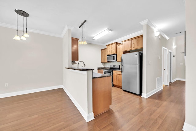 526 Valparaiso Pkwy Unit B, Valparaiso, FL 32580 - kitchen featuring stainless steel appliances, crown molding, light wood-style flooring, a peninsula, and tasteful backsplash