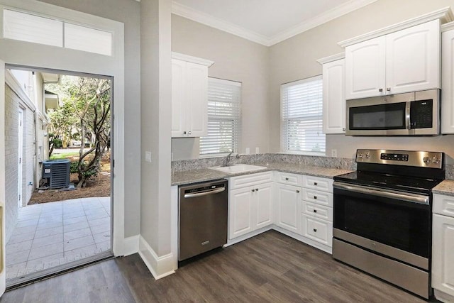 302 Sand Myrtle Trl, Destin, FL 32541 - kitchen with stainless steel appliances, plenty of natural light, dark wood-style flooring, white cabinets, and crown molding