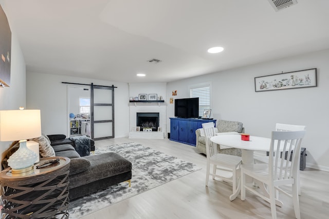 16 Court Dr, Destin, FL 32541 - living room featuring wood finished floors, a barn door, recessed lighting, a brick fireplace, and baseboards