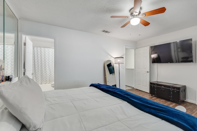 16 Court Dr, Destin, FL 32541 - bedroom featuring wood finished floors, a ceiling fan, a textured ceiling, and ensuite bath