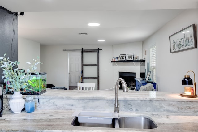 16 Court Dr, Destin, FL 32541 - kitchen with a barn door, a sink, and a fireplace